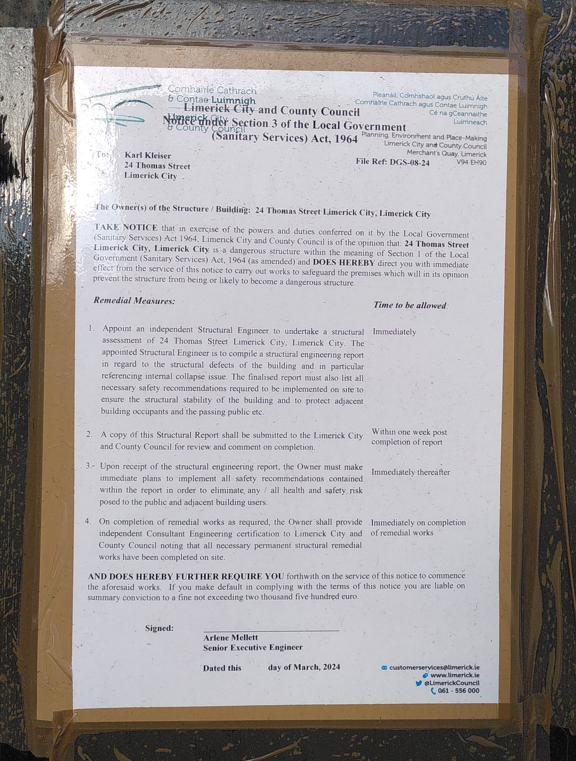 DS-095-23_2025-03-01_Notice Sanitary services Notice taped on the door of a derelict building. The notice is a sanitary notice delivered by the Limerick City and County Council. It states that the building is a dangerous structure and that measures needs to be taken for safety.
